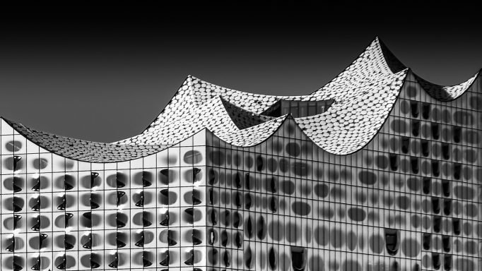 Abstrakte Architektur mit wellenförmigen Strukturen in Schwarz-Weiß.