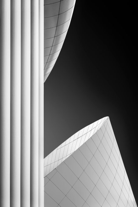 Detailaufnahme von abstrakten, geschwungenen Formen und Säulen in Schwarz-Weiß.