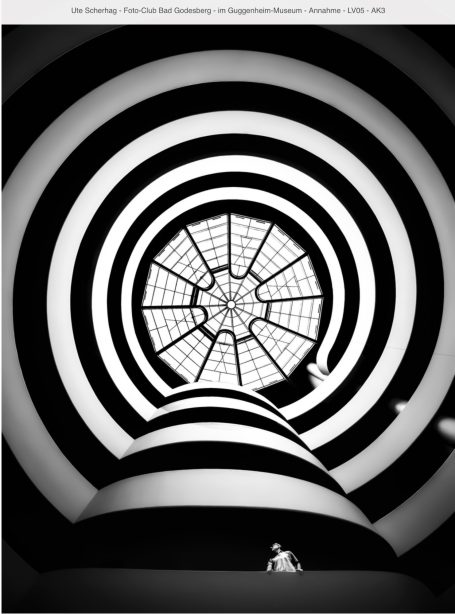 Schwarz-weißes spiralförmiges Muster mit einem zentralen Fenster und einer Figur am Boden.