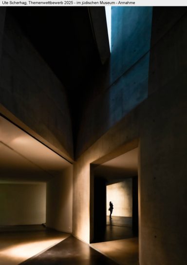 Dunkler Raum mit geometrischen Wänden und schmalem Lichtstrahl, silhouettierte Person.
