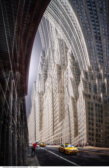 Stadtansicht mit markanten architektonischen Linien und gelben Taxis auf der Straße.